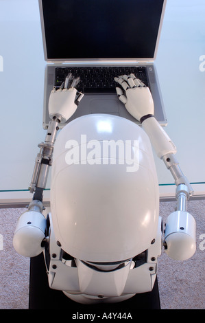 Weibliche humanoide Roboter, die einen Laptop-Computer in Betrieb Stockfoto