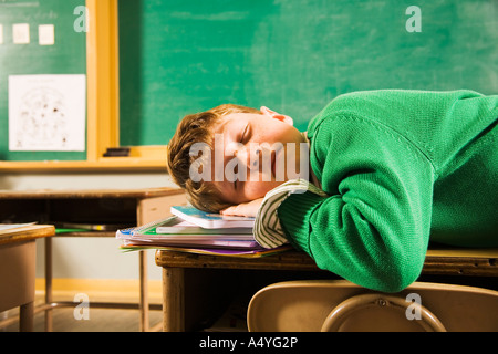 Jungen schlafen auf dem Schreibtisch im Klassenzimmer Stockfoto