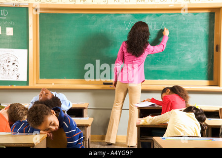 Studenten schlafen, während Lehrer an die Tafel schreibt Stockfoto