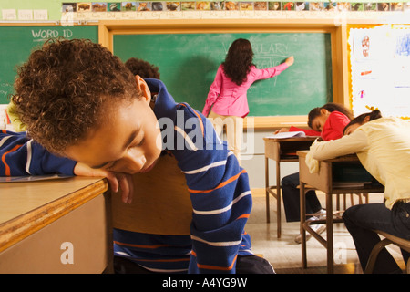 Studenten schlafen, während Lehrer an die Tafel schreibt Stockfoto