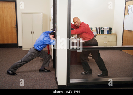 Geschäftsmann hält Bürotür gegen Co-worker Stockfoto