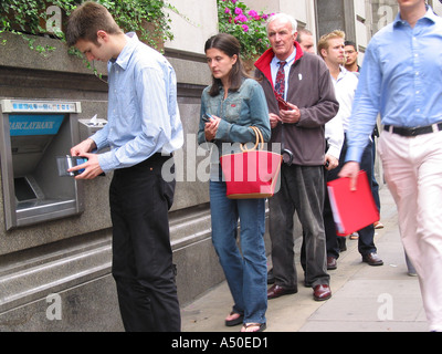 Schlange von Menschen an einem Geldautomaten ATM Stockfoto