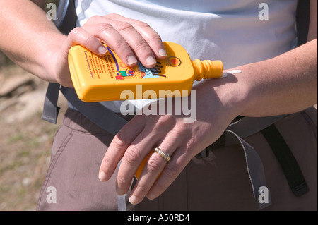Frau Walker, die Anwendung von Sonnenschutzmitteln Stockfoto