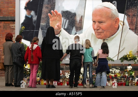 Eine Gruppe von Menschen Hände kam, begleitet durch einen christlichen religiösen Blick auf die brennenden Kerzen in Gedenken an Johannes Paul II. Stockfoto