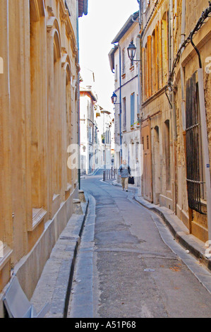 Ein Mann mit einer Aktentasche zu Fuß auf einer kurvenreichen Straße in der Altstadt von Avignon, Vaucluse, Rhône, Provence, Frankreich Stockfoto