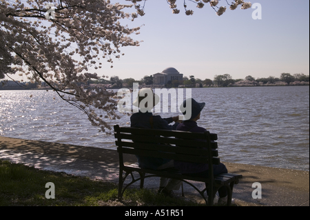 Älteren japanischen Ehepaar sitzt auf der Bank am Ufer des Potomac River Gezeitenbecken Washington DC USA Stockfoto