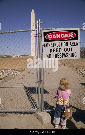 Kleines Kind schaut durch Maschendrahtzaun in Bauzone rund um das Washington Monument Washington DC USA Stockfoto