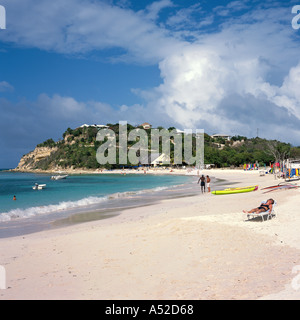 Frau touristischen Sonnenbaden am Strand mit weit entfernten Menschen und Kajaks im Long Bay Antigua Karibik Stockfoto