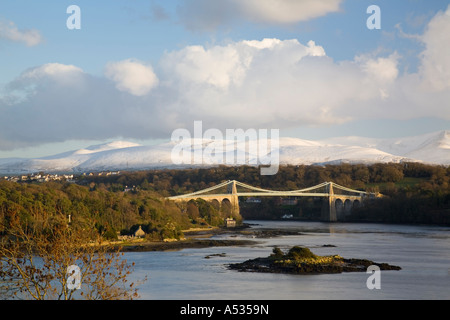 Menai Suspension Bridge von Thomas Telford 1826 über Menaistraße gebaut mit Schnee auf Carneddau Berge. Menai Bridge ISLE OF ANGLESEY Wales UK Stockfoto