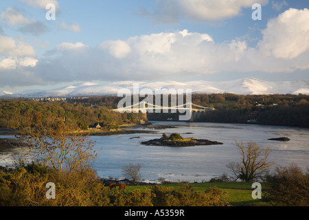 Blick auf Menai Hängebrücke 1826 über Menai Strait mit Schnee in den Bergen von Anglesey North Wales UK Großbritannien Stockfoto