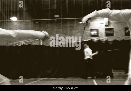 Getöntem schwarz / weiß Bild von zwei Fechter im Wettbewerb in der Sporthalle. Stockfoto