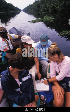 Costa Rica Tortuguero weibliche Naturführer verweisen auf Vogel-Reiseführer für Touristen während Kanal Regenwald Bootstour Stockfoto