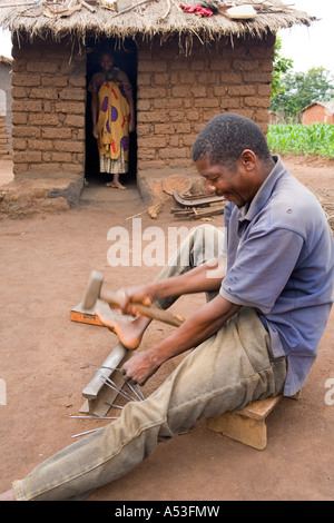 Schmied schlagen Runde Federn in flache Nadeln für Nähen Tabak Säcke in das Dorf Muzumanzi, Malawi, Afrika Stockfoto