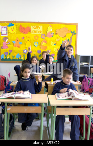 Libanon BEIRUT Schulklasse mit Kindern in Uniformen, die Erziehung ihrer Hände, Antworten mit vollen Schultaschen ehrenamtlich Stockfoto