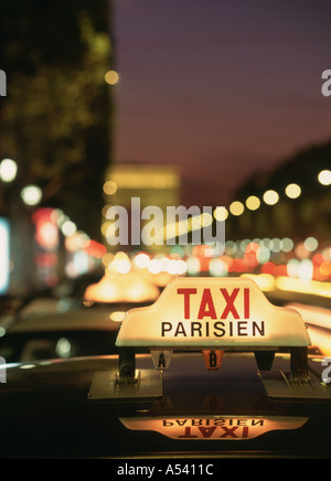 Taxi auf Champs-Elysées mit dem Arc De Triomphe nachts Stockfoto