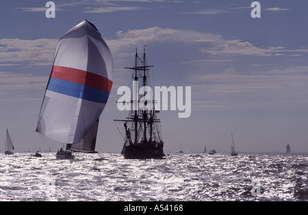 Eine Yacht-Rennen unter SPI vorbei an eine Nachbildung des quadratischen Rigger im Solent vor der Isle Of Wight England UK Stockfoto