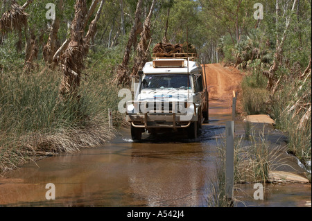Toyota Landcruiser fährt durch eine Furt über Fortescue River Pilbara Region western Australien WA Stockfoto