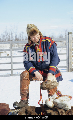 Nils-Ante Kuhumen Sami Lapp Rentierzüchter tragen traditionelle handgefertigten Kleidung Rentier Haut außerhalb der Fütterung seiner Herde in Stockfoto