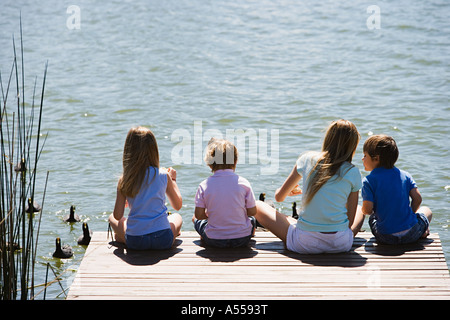 Kinder füttern Enten auf einem See Stockfoto