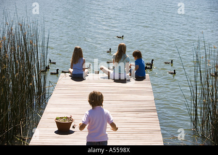 Kinder füttern Enten auf einem See Stockfoto