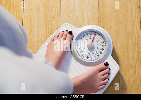 Frau stehend auf Waage Stockfoto