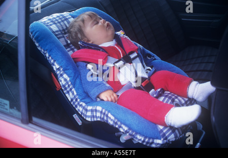 Babymädchen (Alter von neun Monaten) im Kindersitz im Auto schlafen. Stockfoto