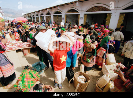 Ein vietnamesischer junge trägt Kunststoffbehälter verwendet im Verkauf von hausgemachten Schnaps auf dem Markt in Nordvietnam BacHa Stockfoto