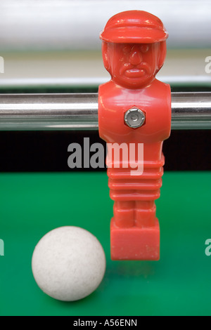 Tischfußball. Rote Stürmer dribbelt mit dem Ball. Stockfoto