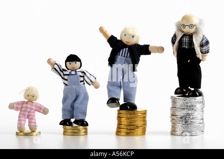 Figuren stehend auf Haufen von Münzen Stockfoto