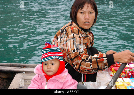 Weibliche Händler mit Kind auf einem Boot in der Halong Bucht Vietnam Stockfoto