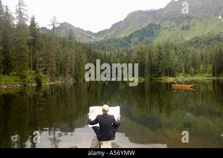 Geschäftsfrau, die Zeitungslektüre am See, Rückansicht Stockfoto