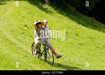 Paar Reiten Fahrrad in Wiese Stockfoto