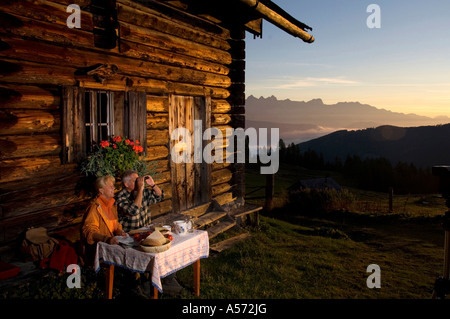 Reifen Sie paar sitzen vor der Alphütte, Sonnenuntergang Stockfoto