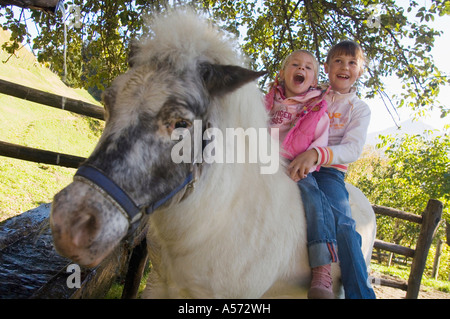 Zwei Mädchen sitzen auf pony Stockfoto