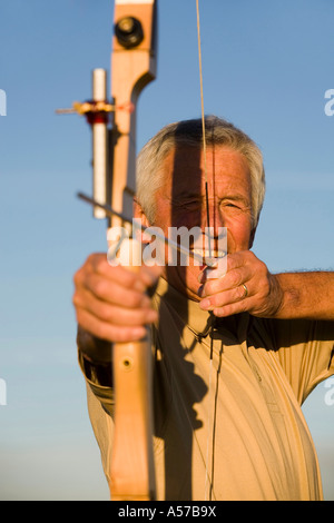 Ältere Erwachsene Frau mit Pfeil und Bogen, close-up Stockfoto