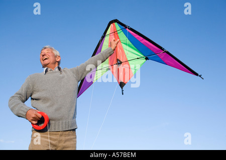 Senior woman fliegende Drachen, lächelnd, niedrigen Winkel Ansicht Stockfoto