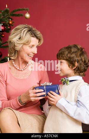 Kleiner Junge geben Weihnachtsgeschenk für Oma Stockfoto