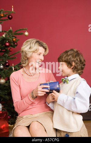 Junge (4-7) geben Weihnachtsgeschenk für Oma, Lächeln Stockfoto