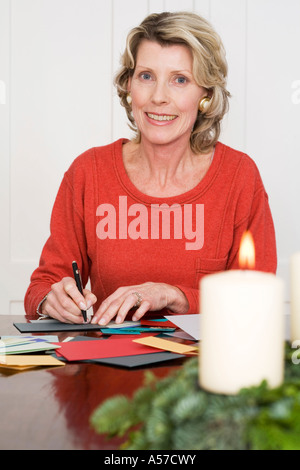 Frau schreiben Weihnachtskarten, Lächeln, Porträt Stockfoto