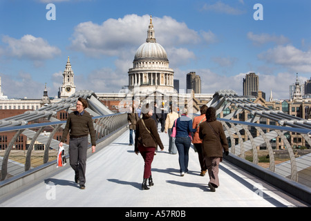 Fußgänger überqueren die Millennium Bridge London England mit St Pauls Cathedral im Hintergrund Stockfoto