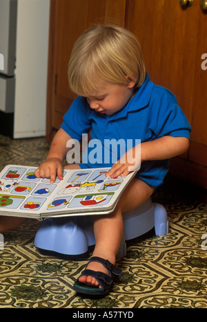 Kleinkind auf Töpfchen Lesebuch Stockfoto