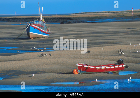 ANGELN BOOTE STRANDED ON SAND BANK BEI EBBE WELLS HAFEN NORFOLK EAST ANGLIA ENGLAND UK Stockfoto