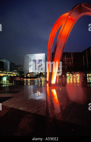 Der Bogen und moderne Skulpturen in La Défense an regnerischen Nacht Stockfoto