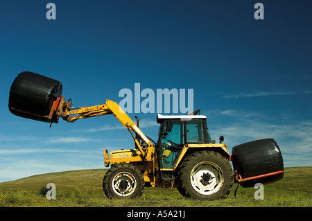 Profil von Traktor und Lader mit Großballen Silage in Plastikfolie Stockfoto