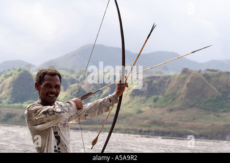 Aeta Mann zeichnet wieder die Zeichenfolge von seinen Bogen in der Nähe von Mount Pinatubo Kratersee, Vulkan, Insel Luzon, Philippinen Stockfoto