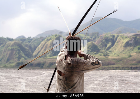 Aeta Mann zeichnet wieder die Zeichenfolge von seinen Bogen in der Nähe von Mount Pinatubo Kratersee, Vulkan, Insel Luzon, Philippinen Stockfoto