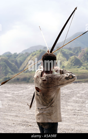 Aeta Mann zeichnet wieder die Zeichenfolge von seinen Bogen in der Nähe von Mount Pinatubo Kratersee, Vulkan, Insel Luzon, Philippinen Stockfoto