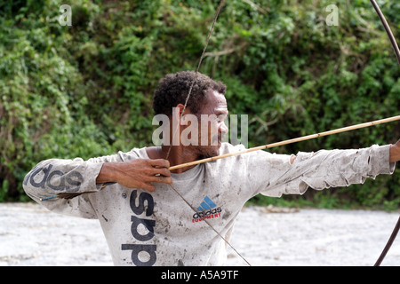 Aeta Mann zeichnet wieder die Zeichenfolge von seinen Bogen in der Nähe von Mount Pinatubo Kratersee, Vulkan, Insel Luzon, Philippinen Stockfoto