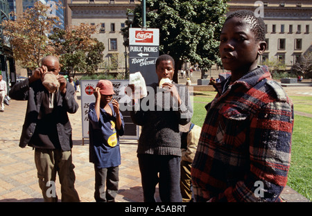 Junge obdachlose Jungen sniffing Glue auf Straßen, Johannesburg, Südafrika Stockfoto