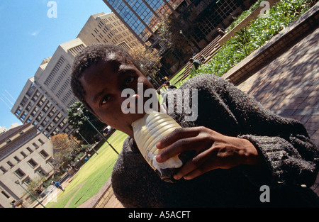 Junge obdachlose junge sniffing Glue auf Straßen, Johannesburg, Südafrika Stockfoto